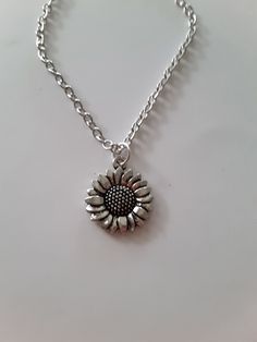 sunflower charm necklace, antique silver charm, dainty, fun gift Silver Alloy Necklace With Flower Pendant, Silver Alloy Flower Pendant Necklace, Silver Charm Necklace In Alloy, Everyday Silver Necklace With Vintage Charm, Handmade Pendant Charm Necklaces In Alloy, Handmade Alloy Charm Necklaces As Gifts, Silver Necklace With Sunflower Pendant, Adjustable Nickel-free Alloy Charm Necklaces, Silver Everyday Charm Necklaces With Flower Charm