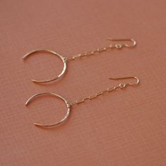 Handcrafted 14k gold filled or sterling silver crescent moon earrings dangle from long rectangle chain. The crescent is formed and hammered from 18 gauge wire into an eye-pleasing crescent shape. Each one is crafted by hand, hammered for texture and then polished to a brilliant shine. While these earrings make a statement on your ears they won't weigh you down. They are very lightweight. Shop Home: HTTP:www.etsy.com/shop/LHJewelryBoutique See More Long Gold Earrings: http://www.etsy.com/shop/lhj 14k Gold Moon-shaped Earrings For Pierced Ears, Dainty Moon-shaped Jewelry With Matching Earrings, Dainty Moon Shaped Jewelry With Matching Earrings, Half Moon Ear Wire Jewelry Gift, Half Moon Ear Wire Jewelry For Gift, Sterling Silver Crescent Earrings With Ear Wire, Minimalist Yellow Gold Earrings With Moon Charm, 14k Gold Crescent Moon Charm Earrings, Nickel-free Yellow Gold Linear Earrings In Sterling Silver