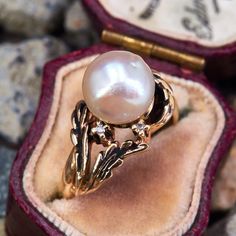 This naturalistic motif ring features a baroque saltwater pearl set amongst twig and leaf designs, accented by two single cut diamonds. The ring is asymmetrical yet balanced, with a great patina. The ring is crafted in 14k yellow gold and is currently a size 7. Vintage Pearl Engagement Ring, Vintage Pearl Rings, Pearl Rings Vintage, Pearl Engagement Ring, Leaf Designs, Saltwater Pearls, Pearl And Diamond Ring, Pearl Set, Vintage Pearls