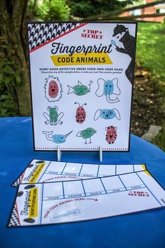 the fingerprint code animals game is displayed on a blue table with trees in the background