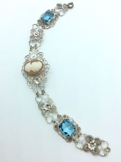 "Work at its best in filagree probably from Spain gorgeous bracelet with a lovely centered cameo and bright blue stone accents Dolly Madison style profile cameo measures 5/8 by 1/2 inch. The clasp is a spring ring style. The bracelet measures 7 .5  long 1\" Wide at center. Gift box with purchase." Ornate Cabochon Bracelet Jewelry, Luxury Blue Filigree Jewelry, Vintage Blue Filigree Jewelry, Ornate Cabochon Bracelet, Luxury Blue Cabochon Bracelet, Dolly Madison, Madison Style, Filigree Bracelet, Ring Style