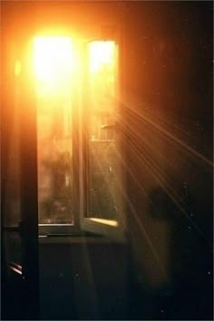 an open window with the sun shining through it