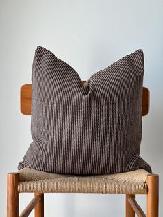 a brown pillow sitting on top of a wooden chair