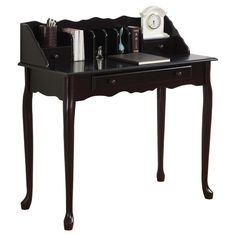 a desk with a clock, pen holder and other items on it's top