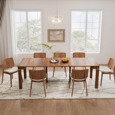 a dining room table with chairs and a rug on the floor