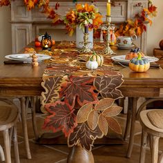 a dining room table decorated with fall leaves