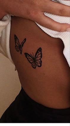 a woman's stomach with two butterflies on it and the bottom part of her belly