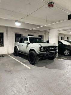 two trucks are parked in a parking garage