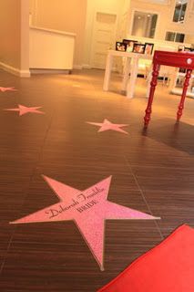 pink stars are on the floor in front of a red table and white chairs with writing on them