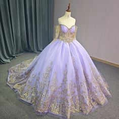 a purple and gold ball gown on display