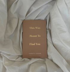 this was meant to find you book laying on the white sheeted bed coverlet