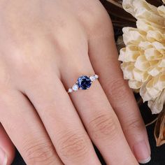 a woman's hand with a blue and white diamond ring