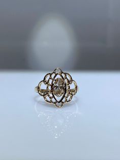 10K yellow gold filigree ring with 0.25 genuine oval shaped diamond. The elongated oval shaped diamond is graded as an SI1 and it has a lovely champagne color that pairs so nicely with the yellow gold. It's 15mm at its widest point and tapers down to 2.5 mm at the base of the shank. The scroll/filigree work of the mounting is simply gorgeous. This would make a very unique engagement ring. It also looks great as a right hand ring. Very rich looking! Finger size is 6. Resizing, if needed, comes co Classic 14k Gold Filigree Ring In Oval Shape, Heirloom Oval Ring With Intricate Design, Gold Filigree Ring With Center Stone For Formal Occasions, Oval Diamond Ring In Gold, Formal Gold Filigree Ring With Center Stone, Oval Diamond Rings In Gold, Oval Diamond Gold Rings, Heirloom Oval Filigree Ring With Diamond Accents, Fine Jewelry Ring With Intricate Oval Design