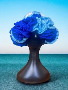 a crocheted blue hat on top of a mannequin head