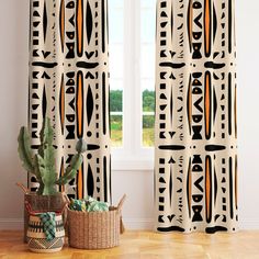 the curtains in this room are decorated with african style patterns and geometric shapes, along with a cacti basket