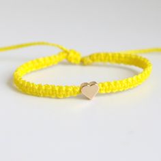 This bracelet is made of yellow waterproof rope and a gold plated heart charm. Trendy Gold Friendship Bracelets For Valentine's Day, Casual Gold Jewelry With Adjustable Cord, Everyday Gold Friendship Bracelets With Heart Charm, Trendy Gold Braided Friendship Bracelet, Casual Gold Braided Bracelets For Everyday, Gold Nylon Cord Friendship Bracelets As Gift, Gold Casual Jewelry For Valentine's Day, Casual Gold Jewelry For Valentine's Day, Trendy Gold Braided Bracelet With Sliding Knot