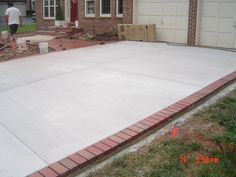 a man is standing in front of a house with a large slab on the ground