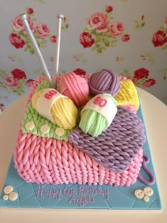 a birthday cake made to look like yarn and knitting needles