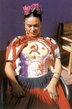 a woman sitting on top of a wooden floor wearing a skirt and headpieces