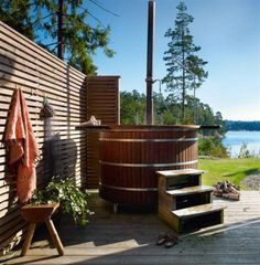 a hot tub sitting on top of a wooden deck next to a body of water