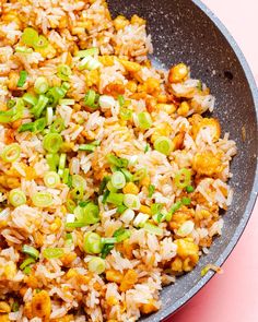 a pan filled with rice and vegetables on top of a table