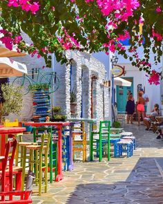 colorful tables and chairs are lined up on the sidewalk