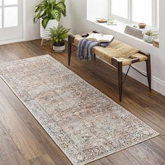 a large area rug in the middle of a room with wooden floors and white walls