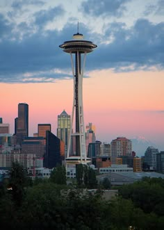 the space needle in seattle at sunset with city skyline in the background