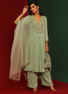 Features a jade georgette kurta with sequin work velvet yoke and 3D embellishments at the hem. This V-neck kurta has circular tassels on the sleeves hem. Paired with hem tasseled dupatta. An ideal indo western pick for Mehendi and wedding guests. Composition : Kurta and Pants: Georgette, Dupatta: Organza, Lining: Shantoon Care: Dry Clean Only and Vacuum Storage All products can be customised for sleeves, length of blouse and neck design Delivery : 4-6 weeks as the product is hand crafted. Check Georgette Kurta Sets For Women, Mahima Mahajan, Kurta Set With Dupatta, Kurta And Pants, Lehenga Style Saree, Georgette Kurta, Indian Bridesmaid Dresses, Color Jade, Georgette Dupatta