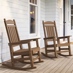 two wooden rocking chairs sitting on a porch