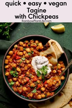 a bowl filled with chickpeas next to pita bread