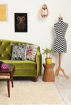 a green couch sitting next to a wooden table