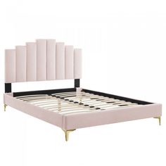 an upholstered bed frame with gold legs