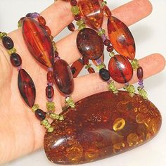 Necklace Stone(s): 3 strands top grade authentic Baltic honey amber (pendant amber measures 3 x 1.5 inches) with authentic amethyst and authentic peridot Necklace Length: 20 inches Deep: 1.5 inches Weight: 80.7 grams Clasp: Toggle Stamp/Mark: N/A Serial Number: n1247 Amber, an organic gemstone, is the fossilized sap of prehistoric trees which grew up to 50 million years ago. The stone has been used for jewelry since the time of Christ. The world's finest amber comes from the region around the Ba Prehistoric Trees, Peridot Necklace, Necklace Stone, Amber Pendant, Necklace Length, Stone Necklace, The Stone, Necklace Lengths, Amber