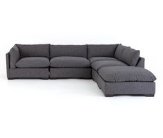 a gray sectional couch with pillows on it's back and the seat folded out