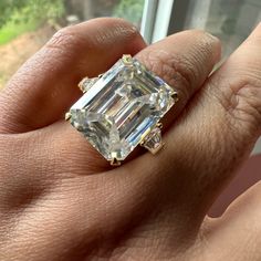 I Purchased This Gorgeous Ring From A Seller In India Ages Ago, But Somehow It Just Hasn’t Felt Like Mineis It Yours? With An Emerald-Cut Center Stone Measuring Approx. 13.5 X 18mm, This Ring Has A Dew (Diamond Equivalent Weight) Of About 20 Carats. Moissanite, However, Is Less Dense Than Diamond, So The Actual Weight Is Less. The Center Stone Is Flanked In Classic Three-Stone Style By Two Trapezoidal Moissanites Each Approx. 5 X (5, 3) Mm. If You’re Not Familiar With Moissanite, Do Your Homework Before Purchasing This Ring. Moissanite Passes Cheap Diamond Testers But Is Given Away By Its Outrageous Double-Rainbow Sparkle Endowed By Double Refraction And High Dispersion. At Mohs 9 Unique Emerald Cut Engagement Rings, Gold Band Engagement Rings, Do Your Homework, Rainbow Sparkle, Emerald Cut Ring, Double Rainbow, Emerald Cut Moissanite, Gorgeous Ring, Emerald Cut Rings