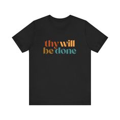 This classic unisex 100% cotton jersey short sleeve tee features the words "Thy Will Be Done" in an array of colors. This is a great shirt for yourself or a friend! FEATURES: -Feature ribbed knit collars to bolster shaping.  -The shoulders have taping for better fit over time.  -Dual side seams hold the garment's shape for longer. -100% cotton. Solid colors are 100% cotton except Heather colors are 52% cotton, 48% polyester -Light fabric (4.2 oz/yd² (142 g/m -Retail fit -Tear away label -Runs true to size COLORS: -Black -Heather Dark Grey -Heather Navy -Navy -White -Heather Mauve -Natural -Heather Peach SIZES: -S, M, L, XL, 2XL, and 3XL (Please see image in listing to see size guidelines.) CARE INSTRUCTIONS: Non-chlorine: bleach as needed; Tumble dry: low heat; Iron, steam or dry: medium h Inspirational Black T-shirt With Text Print, Inspirational Short Sleeve T-shirt With Text Print, Inspirational Short Sleeve Streetwear T-shirt, Inspirational Short Sleeve T-shirt For Streetwear, Inspirational Short Sleeve Graphic T-shirt, Inspirational Cotton T-shirt For Streetwear, Inspirational Cotton Short-sleeve T-shirt, Inspirational Short Sleeve Screen Print T-shirt, Inspirational Short Sleeve Shirt With Graphic Print