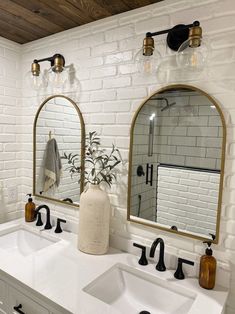 two sinks and mirrors in a bathroom with white brick walls, wood flooring and wooden ceiling