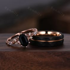 two wedding rings sitting on top of a wooden table next to each other with diamond accents