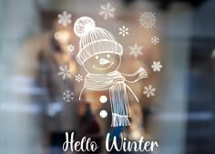 a glass window with the words hello winter written on it and a drawing of a snowman