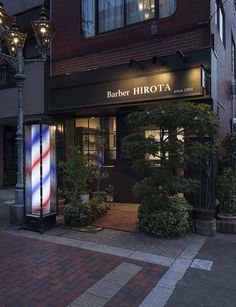 the entrance to a barber shop at night