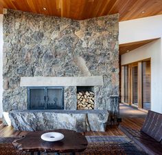 a stone fireplace in the middle of a living room