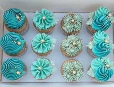 there are twelve cupcakes in the box with blue frosting and flowers on them