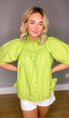 Introducing our Solid Button Up Half Sleeve Top, the perfect addition to your summer wardrobe! This top features a stylish ruffle trim detail at the shoulders, adding a touch of femininity to a classic silhouette. Made from 100% cotton, this top is unlined, woven, and non-sheer, ensuring both comfort and durability. Its lightweight construction makes it ideal for those hot summer days, keeping you cool and stylish throughout the season. Whether you dress it up for a night out or pair it with sho Summer Cotton Top With Ruffled Collar, Summer Cotton Tops With Ruffled Collar, Cotton Top With Ruffled Collar For Summer, Cotton Tops With Ruffled Collar For Summer, Spring Green Ruffled Shirt, Spring Cotton Puff Sleeve Top For Workwear, Spring Trendy Button-up Puff Sleeve Top, Trendy Button-up Puff Sleeve Top For Spring, Trendy Puff Sleeve Button-up Top For Spring