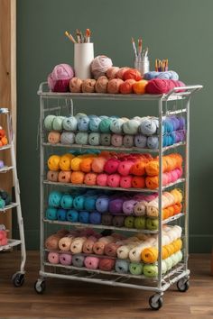 a rack filled with lots of different colored balls of yarn next to a white chair