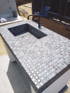 an outdoor sink in the middle of a driveway