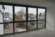 an empty room with large windows overlooking the street