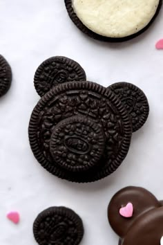 an oreo cookie with white frosting and chocolate mickey mouse cookies next to it