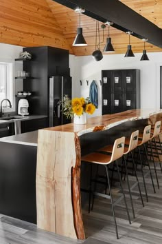 a kitchen with an island made out of wood and metal barstools in front of it