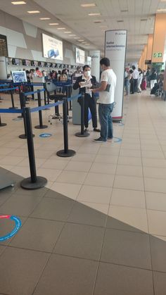 two people standing in line at an airport